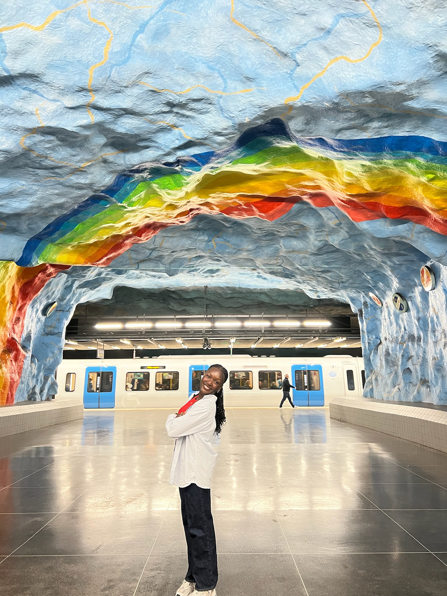 Justine stands under a rainbow icy archway.