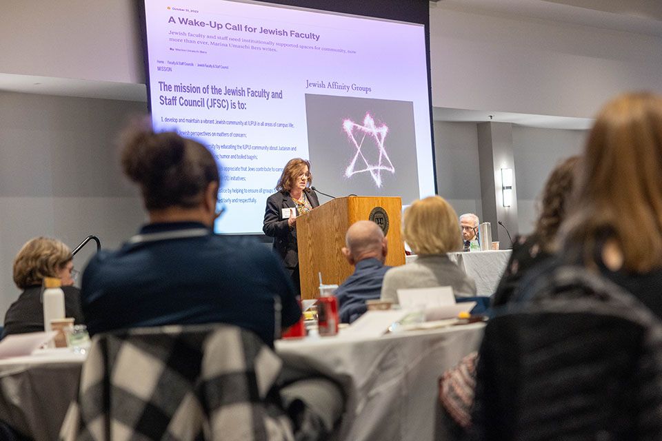 speaker in front of slide with explanation of Jewish affinity groups