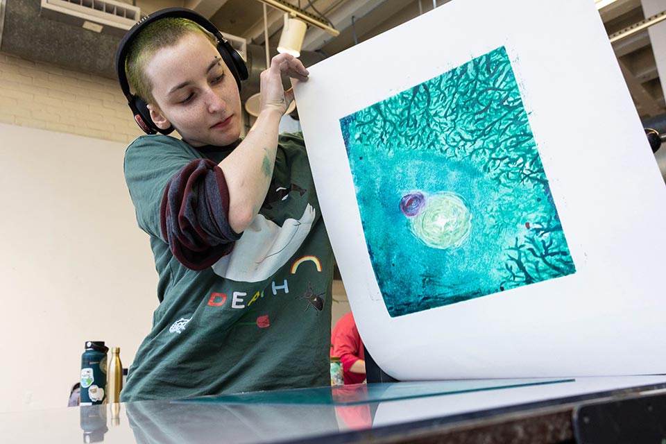 Student working on printmaking in an art classroom