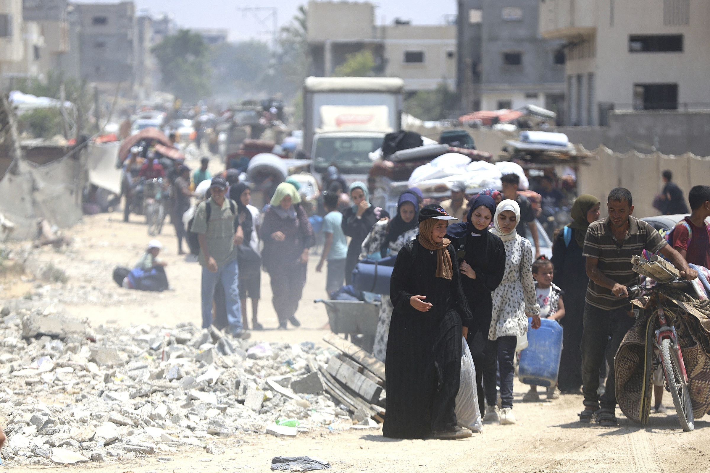 Palestinians flee the Gaza city of Khan Younis amid rubble.