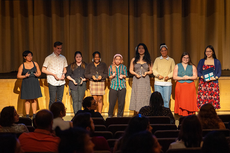 A group of award recipients stand on a stage