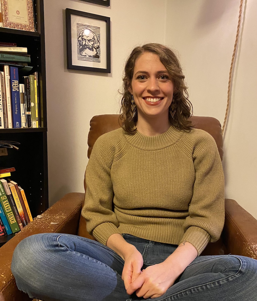 Rachel Dale sits in a chair beside a bookshelf.