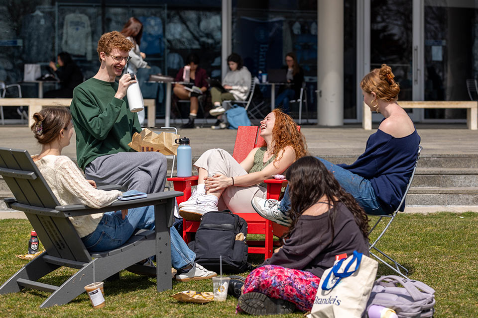 A group of students seated outside enjoying a nice day on campus