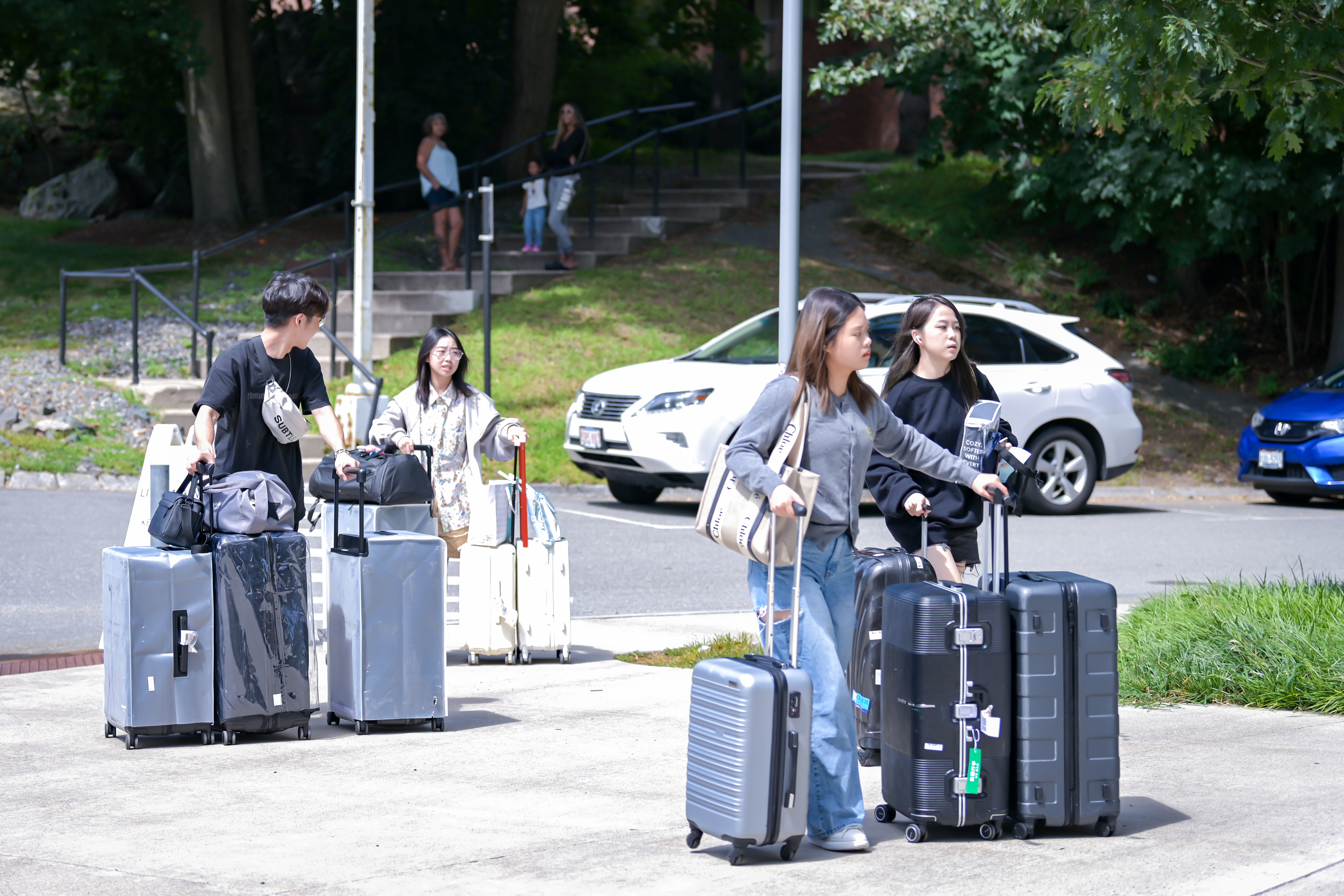 students carrying luggage to check in