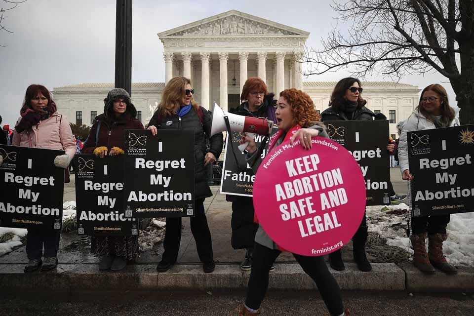 Protesters on both sides of abortion story holding signs