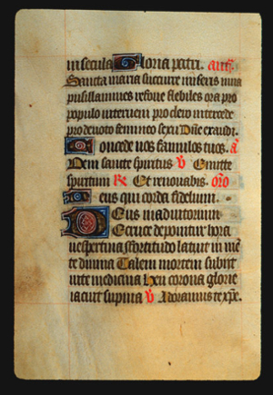 Page 63v, containing a dense block of blackletter text, with 4 illuminated initial letters and several red words and gold counterspaces.