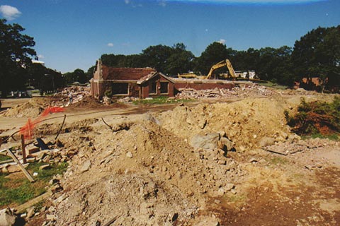 The Last Corner of Ford Hall in the distance behind large mounds of dirt in the foreground, and rubble next to the building in the background.. August 2000