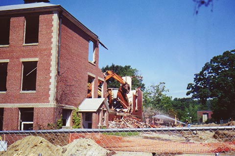 An excavator clears away debris that made up the roof of Ford Hall.