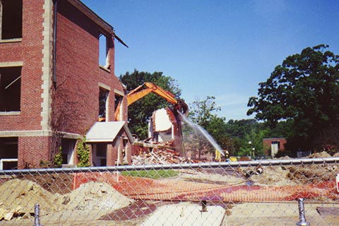 An excavator knocks down the remaining portion of a corner of Ford Hall.