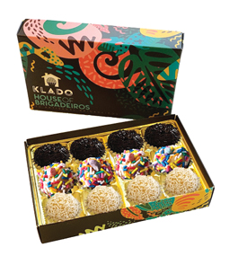 Photo of an open box of truffle-like candies. The cover of the box has a brightly colored abstract design.