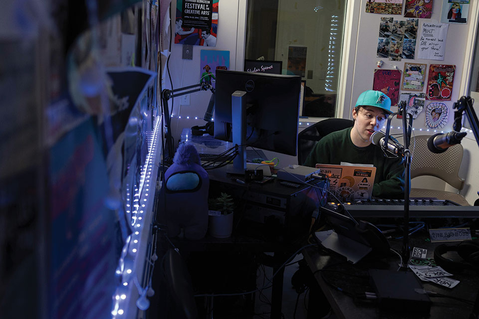 DJ Joshua Hertz ’25 sits at the microphone in the WBRS studio.