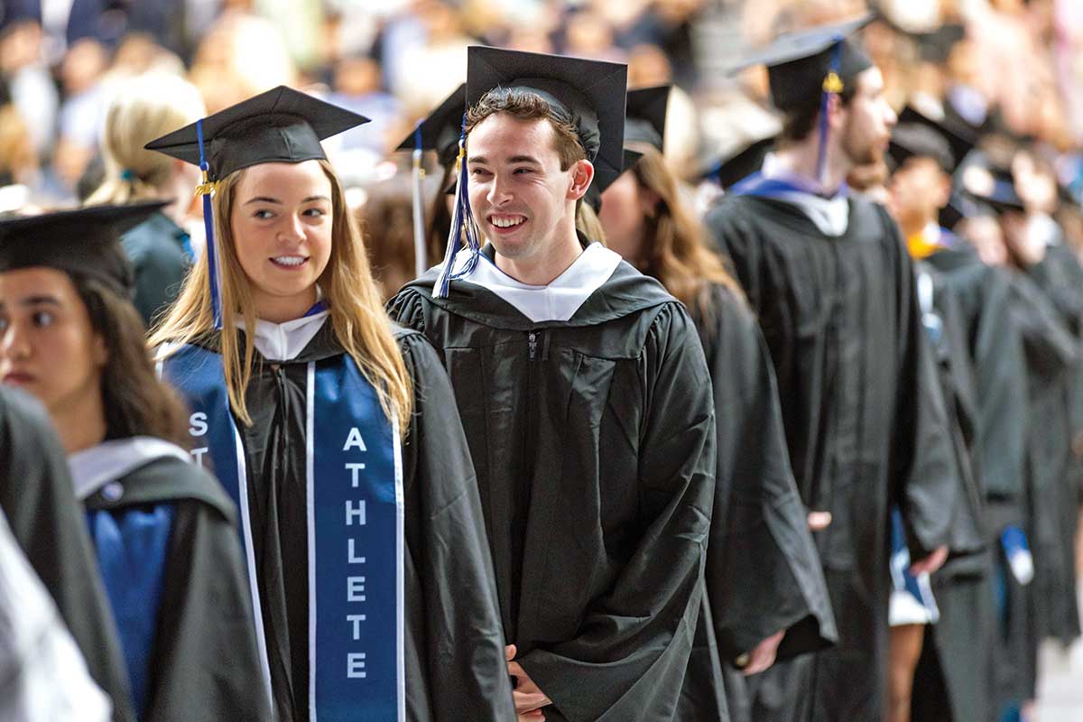 Graduates stand in caps and gowns during the commencement ceremony