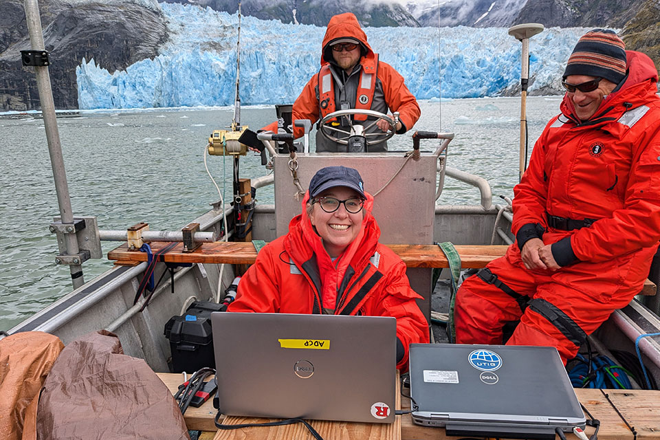 Two boats in front of a large glacier.