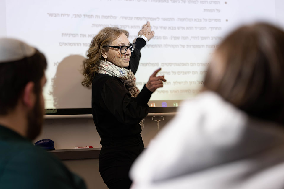 Professor Sara Hascal pointing to Hebrew text on a whiteboard