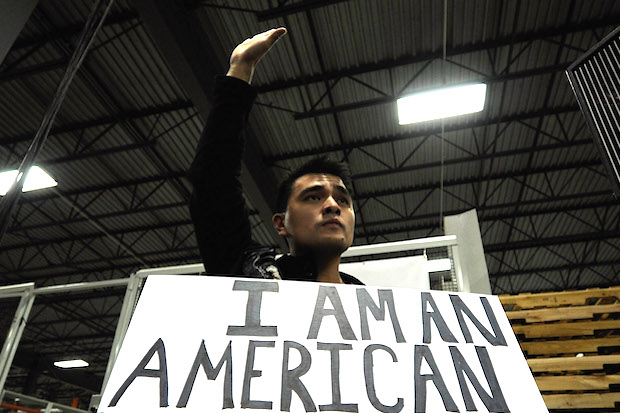 Jose Antonio Vargas holding a sign that says I am an American.