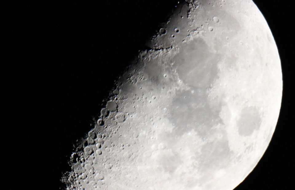 A close-up image of a half-full moon