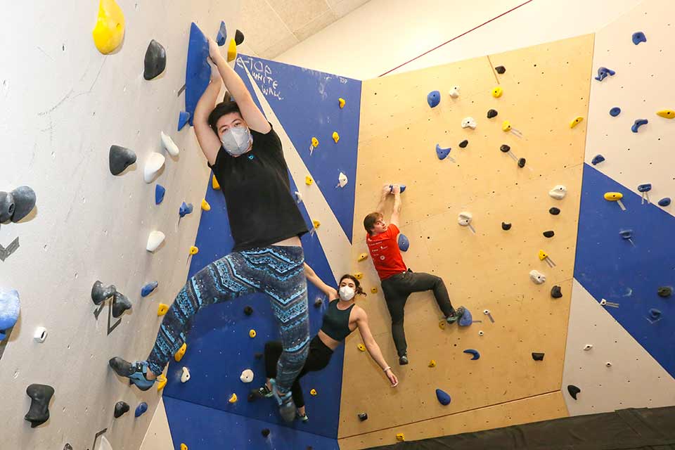 Brandeis students climbing a rock climbing wall