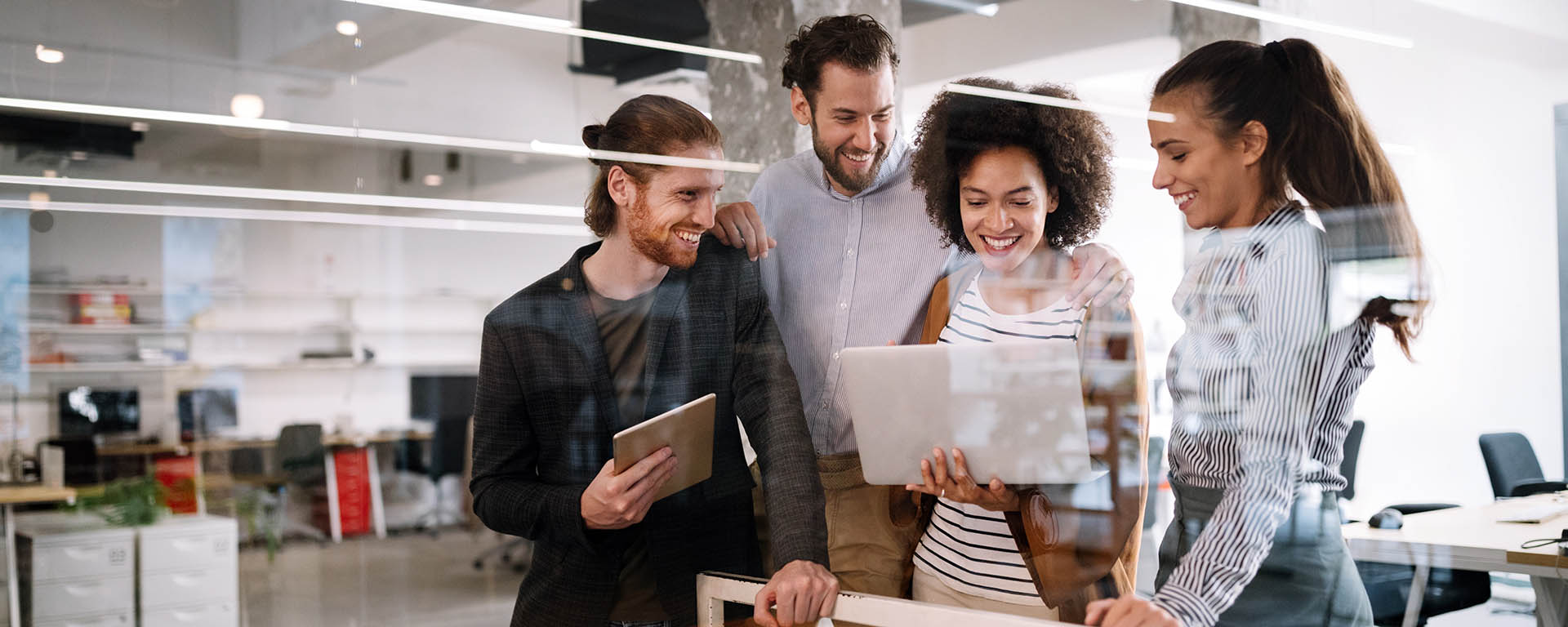 Four people looking at a computer in a marketing setting