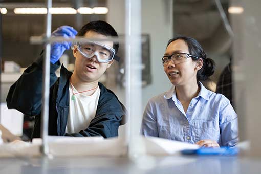 A professor works in a lab with a student.
