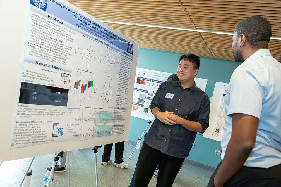 A student explaining their research poster.