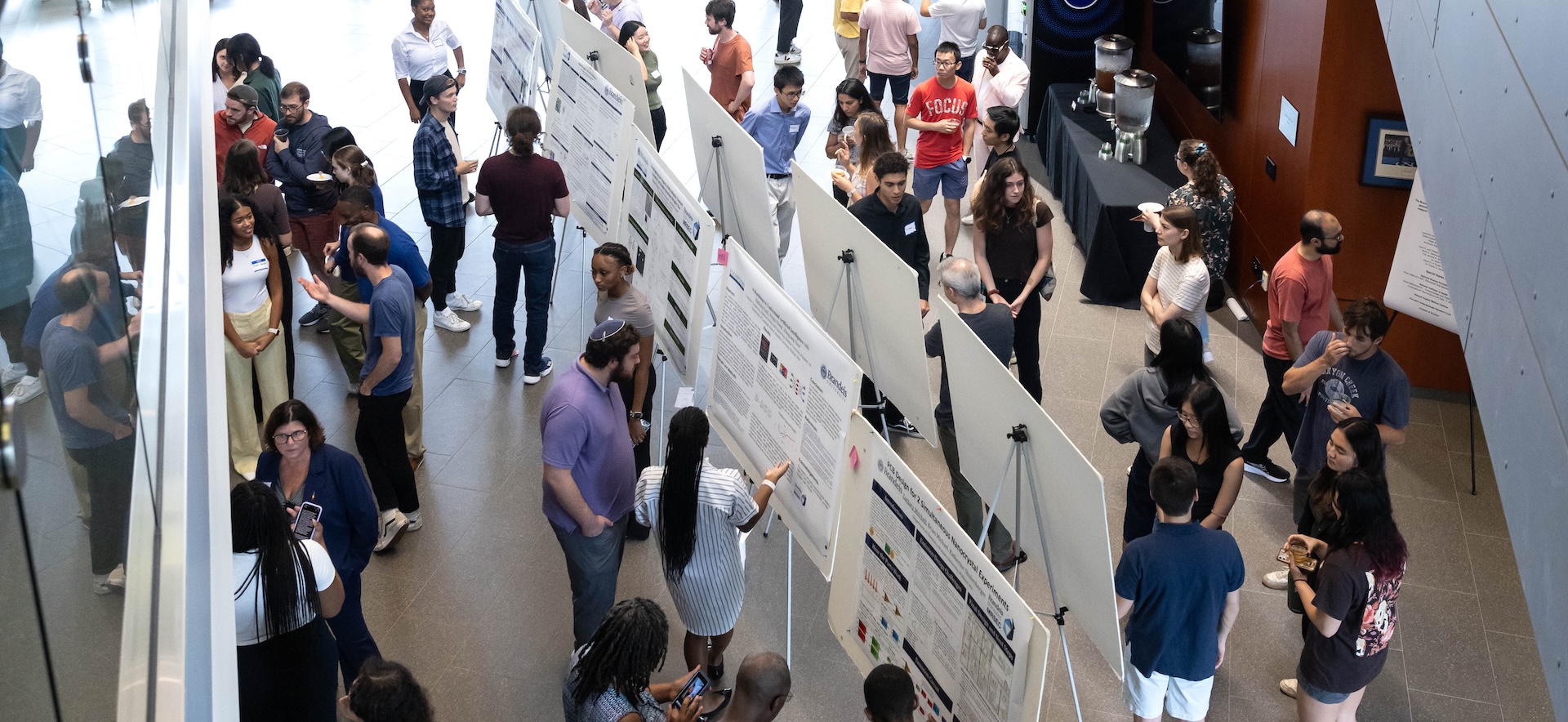 Crowds gather around students presenting their research at poster sessions during SciFest 2024