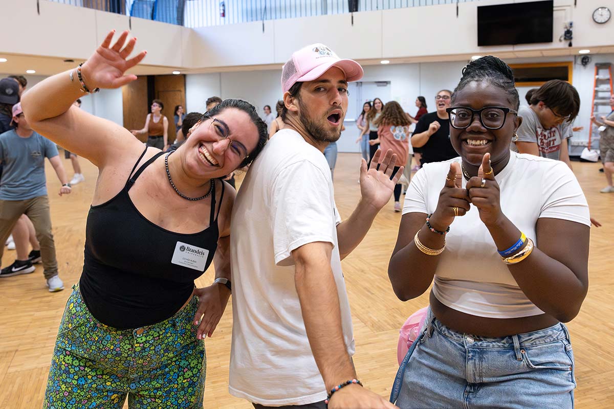 Three people smile and pose for the camera