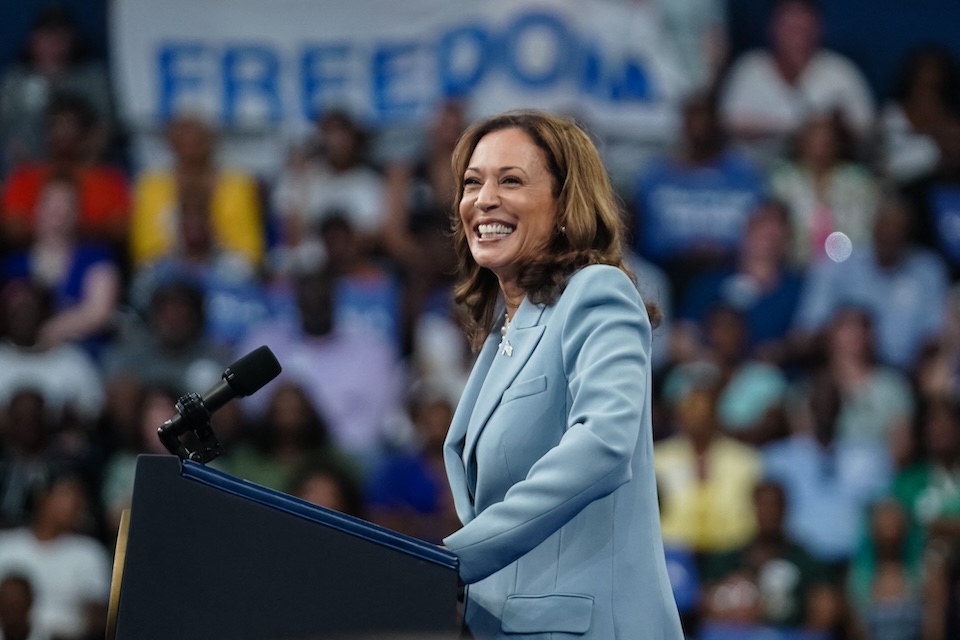 Kamala Harris speaks to an audience from behind a podium at a campaign rally