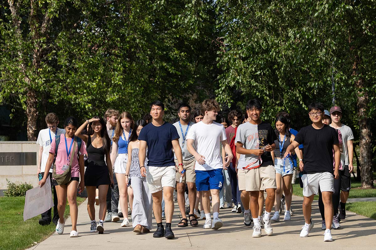 A group of students walks through campus