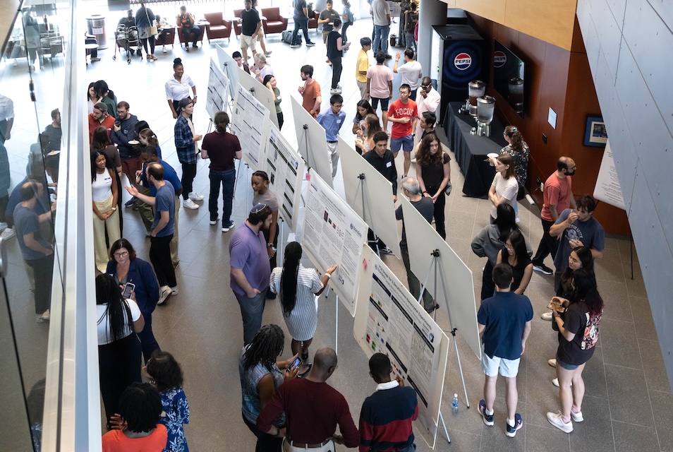 Crowds gather around students presenting their research at poster sessions during SciFest 2024