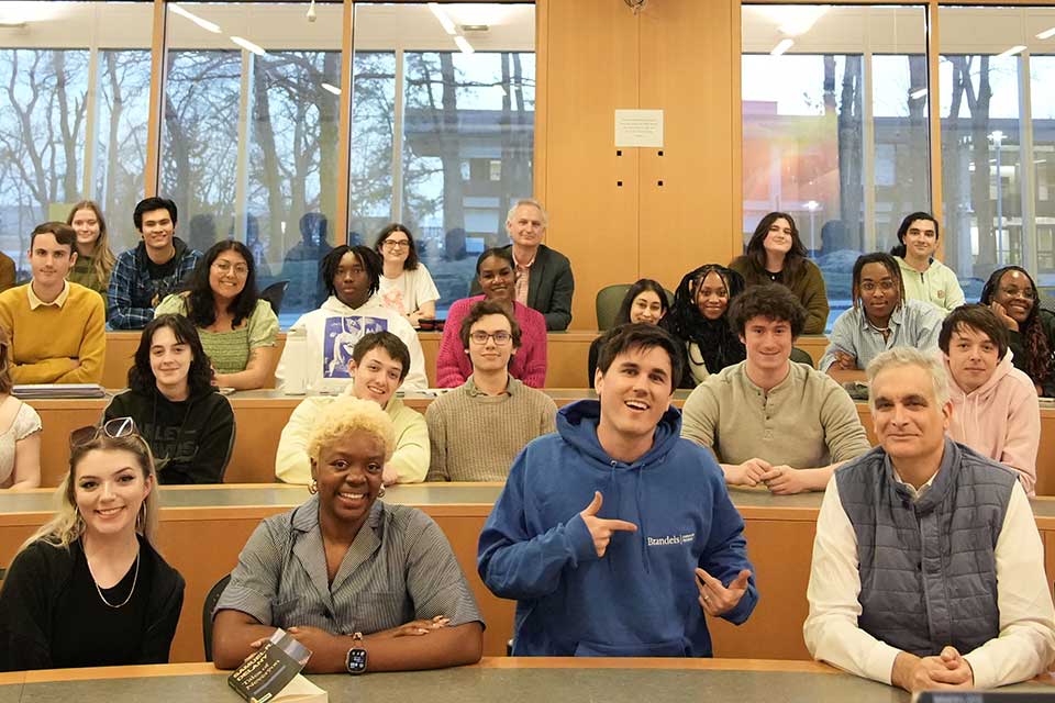 Smiling students and guest speakers in a lecture-style classroom