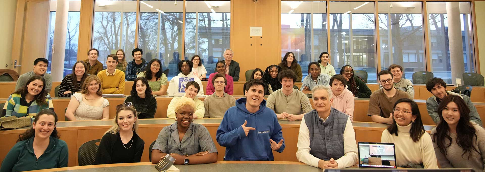 Smiling students and guest speakers in a lecture-style classroom