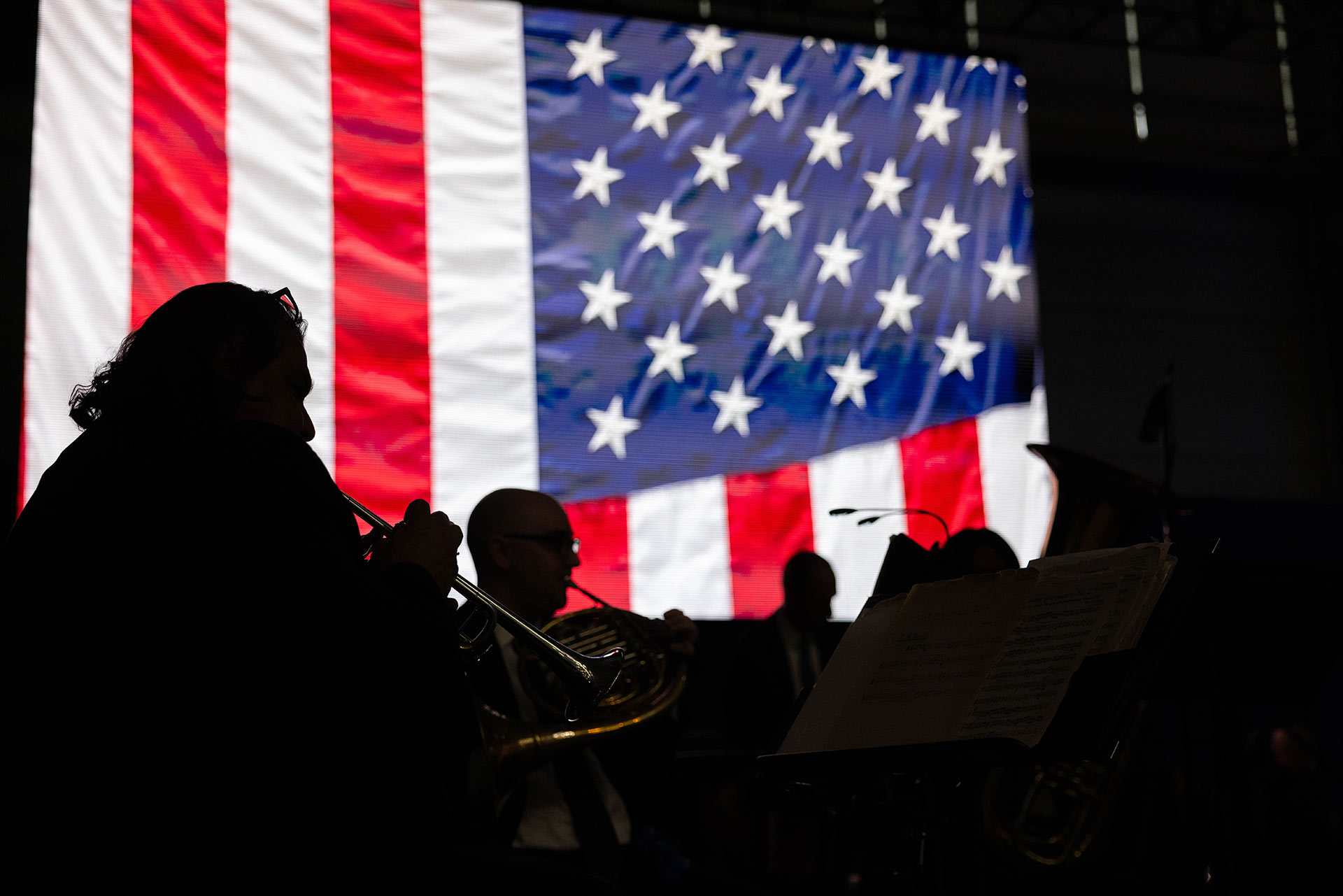 The American Flag with instrumentalists silhouetted in the foreground