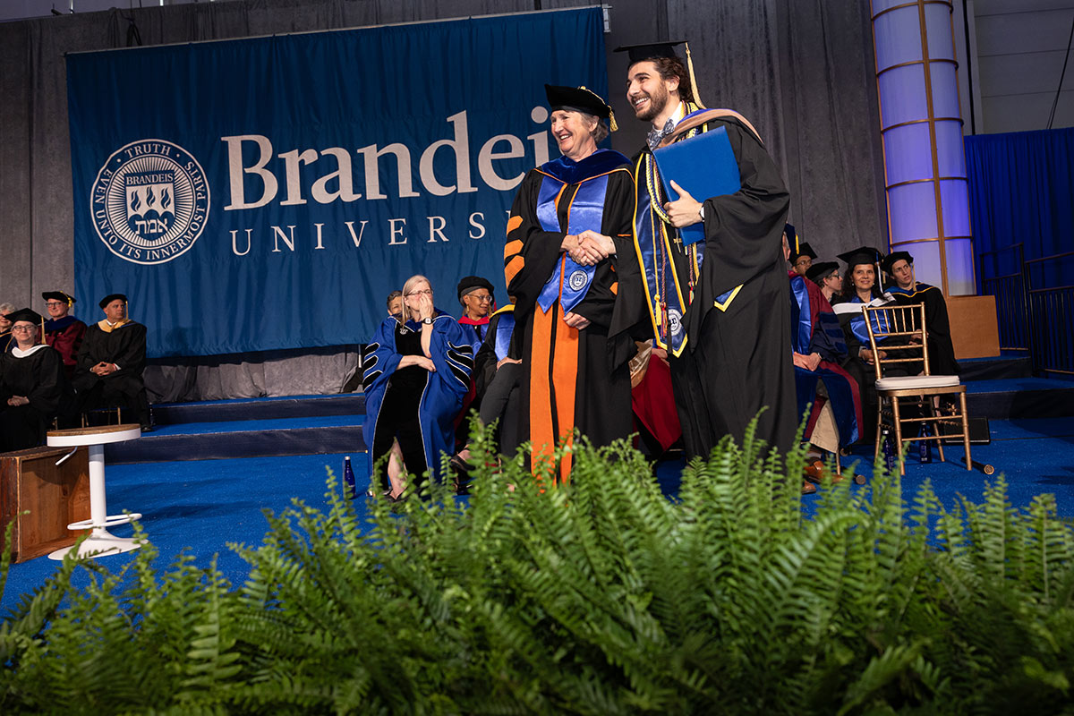 A graduate shaking hands with Lisa Lynch