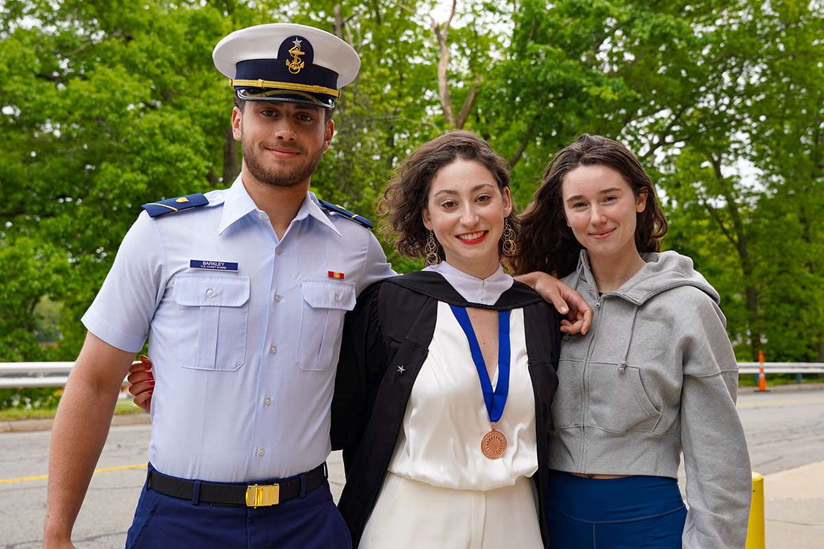 Lauren, posing with her cousin and brother, wears a bronze medal