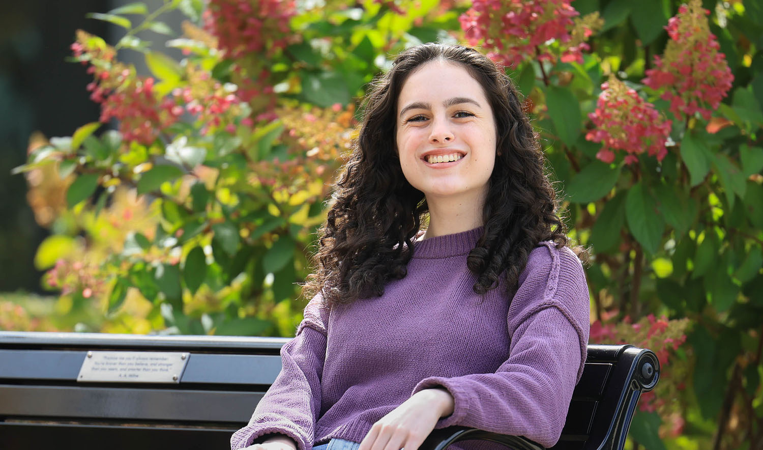 Mandy Feuerman '25 sits on a park bench