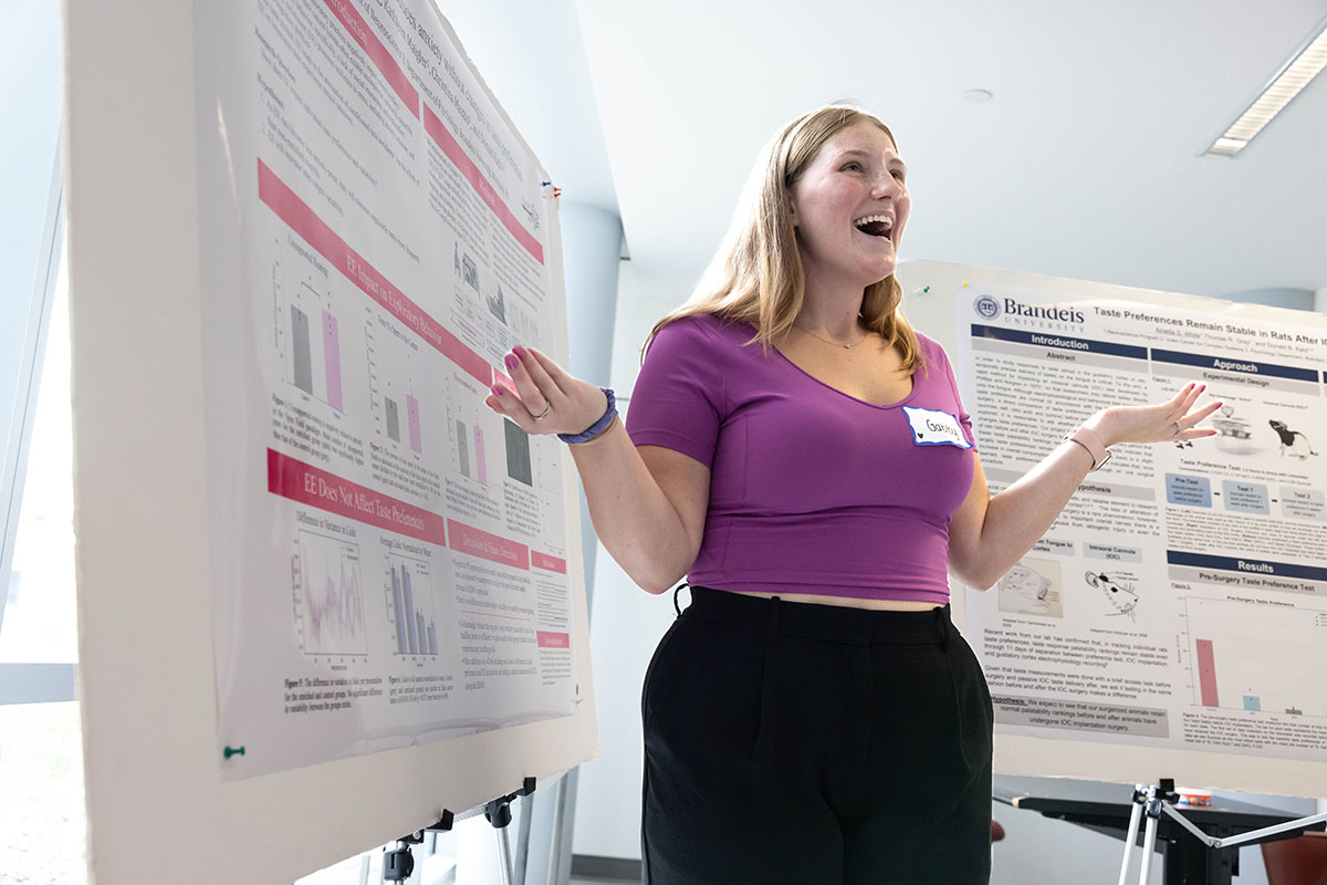 A student smiles and presents research at SciFest.