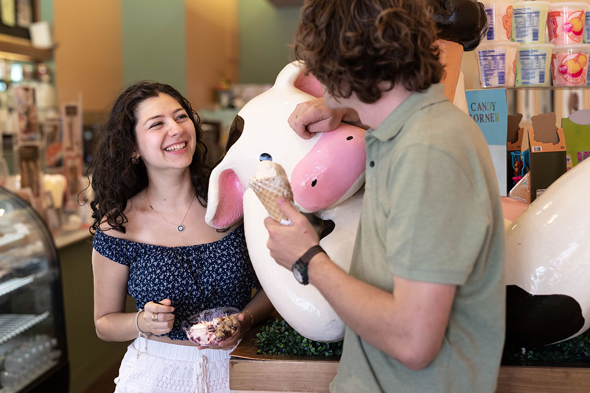 Students holding ice cream smile and talk in Lizzy's Homemade Ice Cream store.