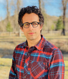 Headshot of Andrew Berns outside wearing a red plaid shirt