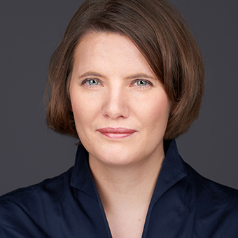 A headshot of Kim Wünschmann with a dark gray background.