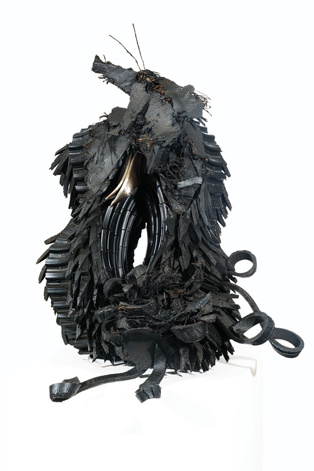 Sculpture made from recycled materials is oblong and evokes natural imagery.