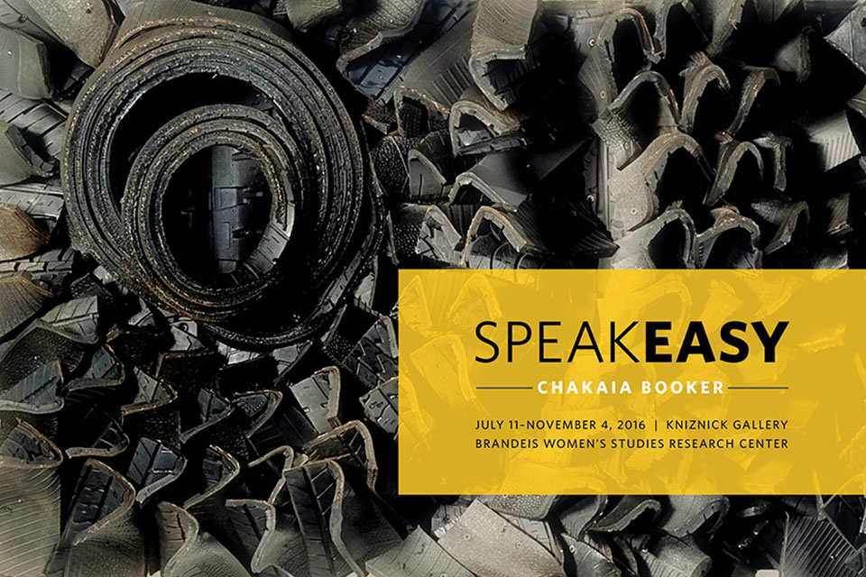 Postcard for Chakaia Booker's exhibit titled "SpeakEasy." The image filling the background, is a zoomed in photo of one of her sculptures, constructed from many layers of recycled tires\. Assembled in a spiral fashion, the tire treads create a rhythmical pattern. Text reads: “SpeakEasy. Chakaia Booker. July 11 - November 4, 2016. Kniznick Gallery. Brandeis Women's Studies Research Center."